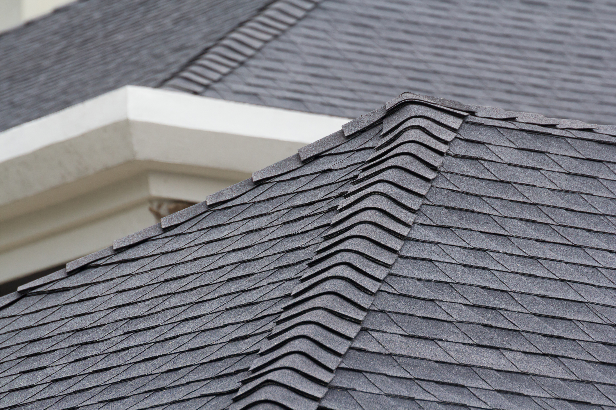 edge of Roof shingles on top of the house, dark asphalt tiles on the roof background. Air